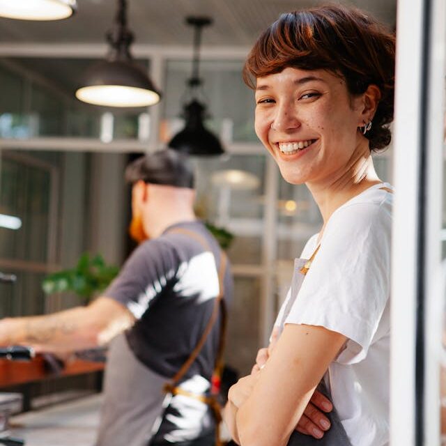 empreendedora-feliz-em-pe Empreendedora feliz e tranquila em seu negócio de sucesso
